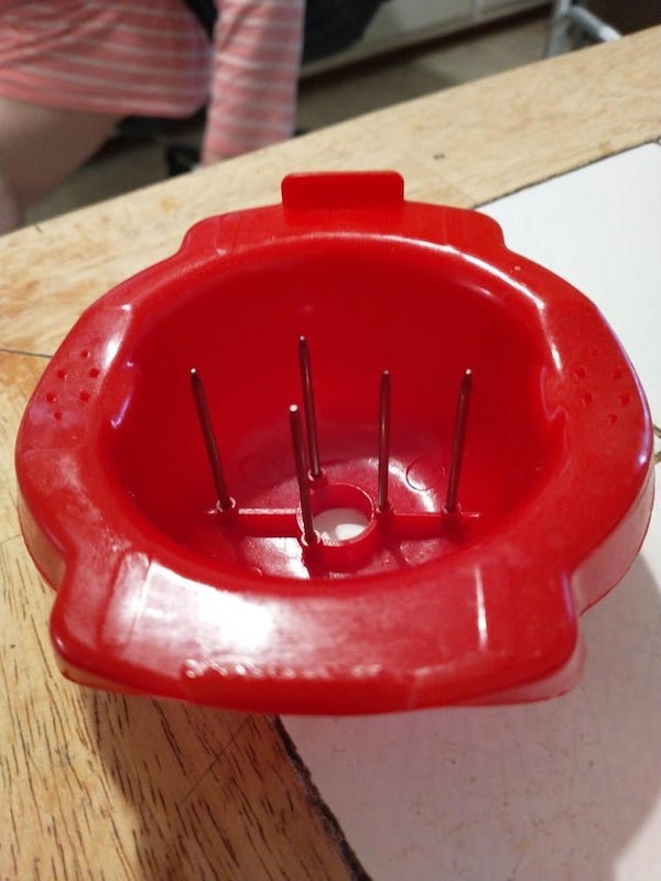 What is this kitchen item? About the right size to hold an orange with 5 pointy spikes.

A: Holds fruits/ veggies to be sliced on a mandoline food slicer