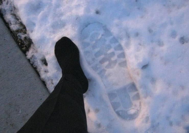 funny pics - huge footprint in the snow next to tiny foot