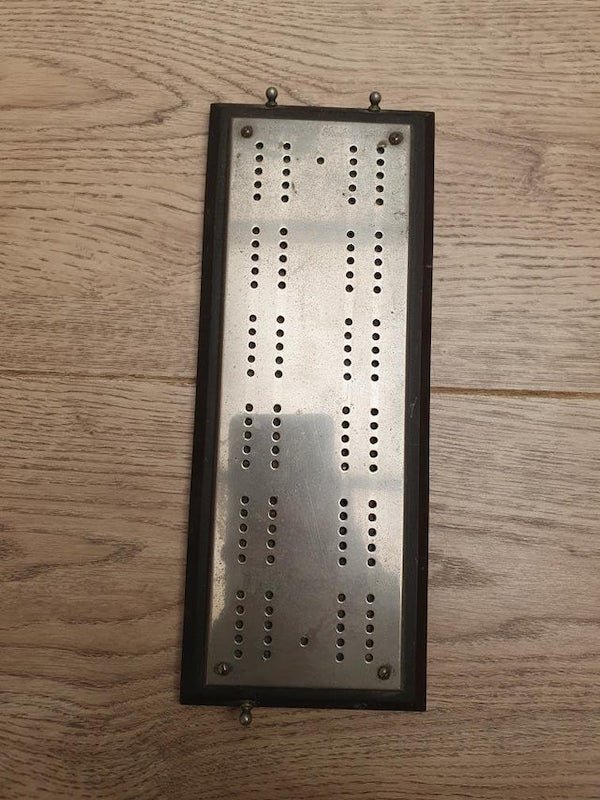 Found at an estate sale. Most of the other items at same sale where dated from 1950s to 80s. Measures 9″ x 4″

A: It has the hole design of a Cribbage board.