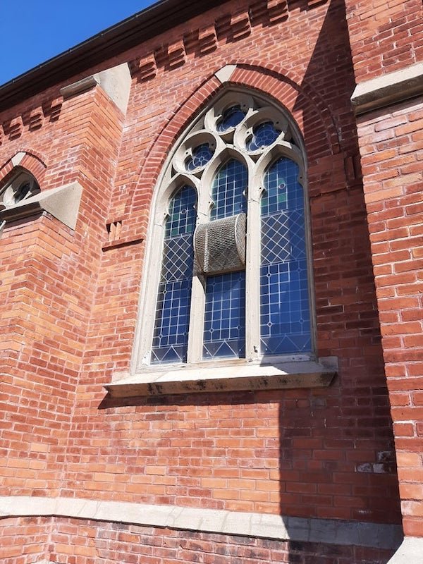 What are these arched cage- like things on the stained glass windows of this church?

A: A piece of the window pivots open within that cage, it probably just keeps birds out.