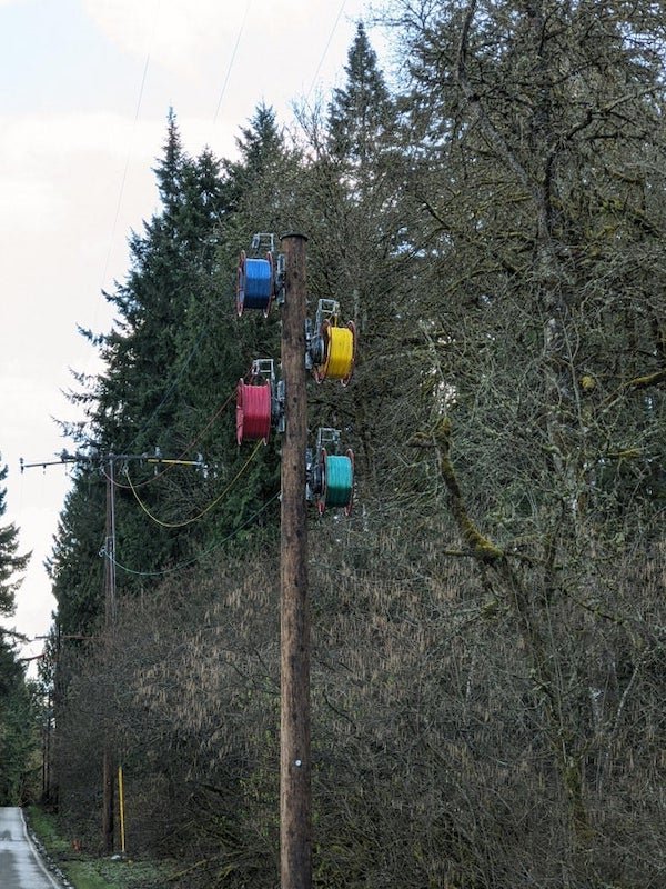 What are these these blue, yellow, red, and green spools on the power lines?

A: It is the Spider system for pulling new power lines.