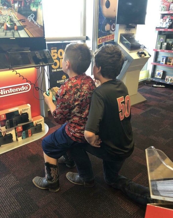 A bro helping his little bro play the Switch.