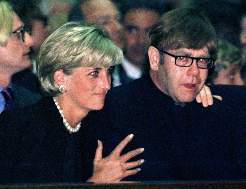 Princess Diana consoles Elton John at the funeral of Gianni Versace. Just over a month later, Diana would die in a car accident, and Elton John would sing at her funeral.