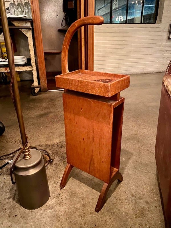 Can anyone identify what purpose this piece of furniture serves?

A: It is a telephone stand. The handle is to move it around the room.