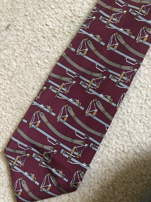 What is the device patterned on this tie I got from the thrift store?

A: I believe that is the leather strap suspension from a Concord Stagecoach.