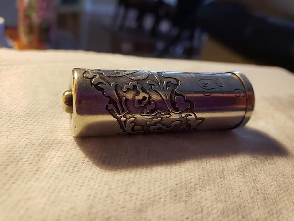 Family heirloom. It’s a little bigger than an AA battery and has about the same weight. It has a tiny pin hole in the top. It also has a combination with numbers 5 to 9. Combo is unknown so don’t know what (if anything) is in there. Feels hollow. Sterling silver that says “Providence” on it.

A: It’s a needle case, there are little compartments inside.