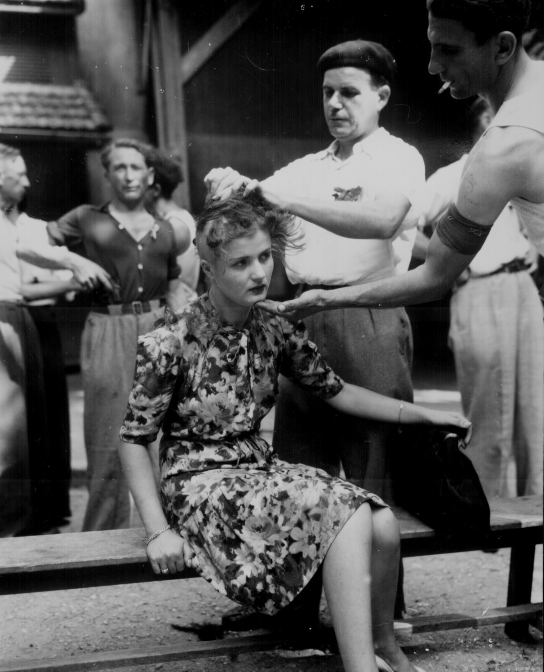 A woman is humiliated for having had personal relations with the Germans. French civilians shave her head as punishment. August 29, 1944