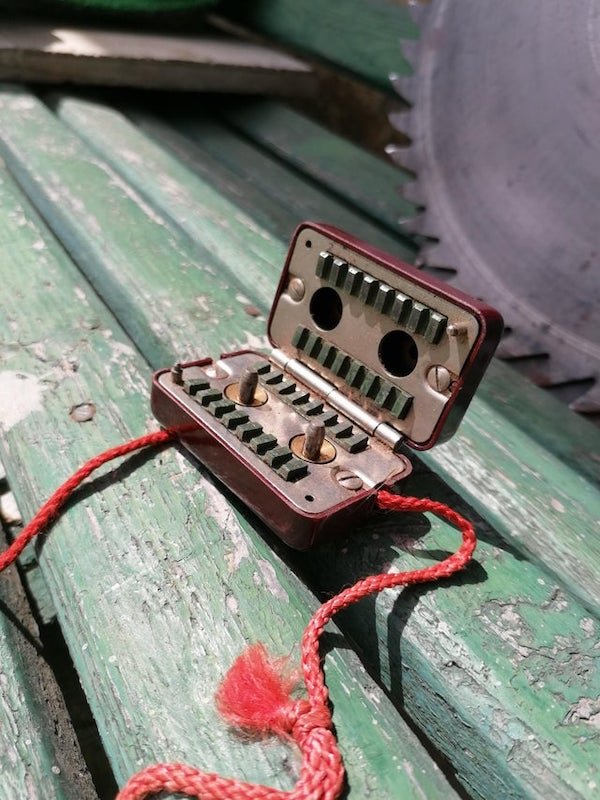 Found in an old house built in 1914, the little gold pins spin if you pull the red cord through. Made by siemens btw.

A: Razor blade sharpener