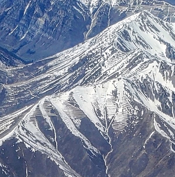 Flying over the Rocky Mountains I noticed horizontal lines across the snow on many mountainsides. What would cause snow to melt/accumulate in this pattern in the mountains?

A: Snow fences to control wind drifted snow in avalanches prone areas.