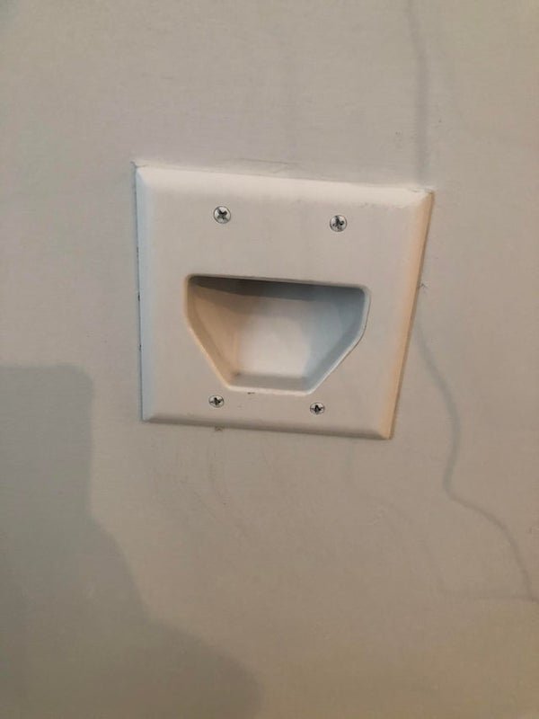 Moving into a new apartment and found this on the wall. It seems like a plastic plate that’s just hollow inside the opening. What could this be for?

A: It’s a port for hiding cables in wall