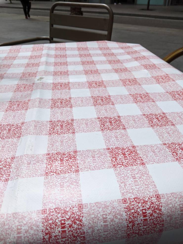 “The classic red checkered pattern of the tablecloth of this restaurant is made of QR codes for their menu.”