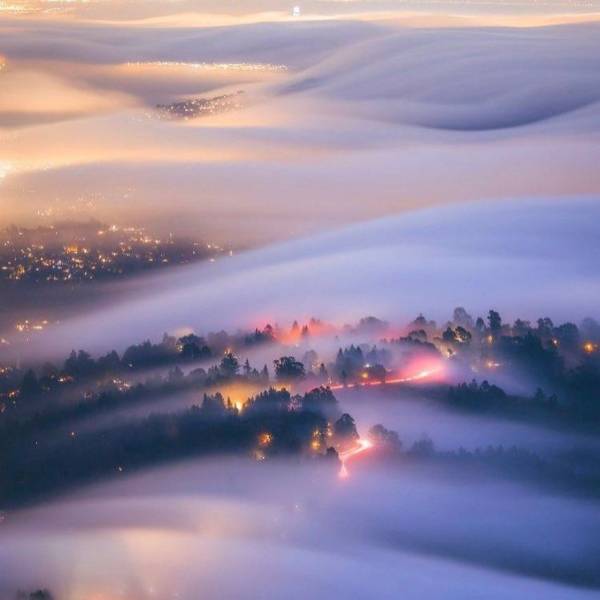 night time fog waves over city