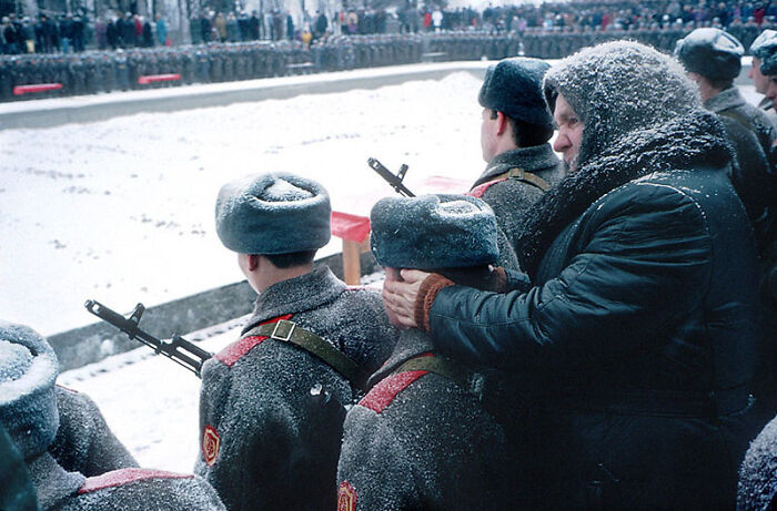 A Babushka Keeps The Ears Of Her Grandson Warm As He Takes An Oath Of Enlistment For The Russian Army. Volgograd, 1994. Photo Taken By Nikolai Ignatiev