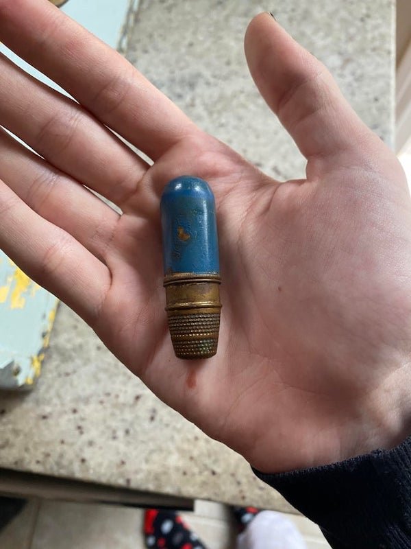 Found in a hunters trunk full of supplies, Canada, sometime between 1950-1980, The bottom dimpled part spins, the top blue part feels like wood, it’s very lightA: If you tug at the brass section does it come off? I’ve seen vintage sewing kits like this where the top is a thimble (which this could easily be, by appearance) and it holds spare needles, pins and a small amount of thread. For repairs on trips and such.