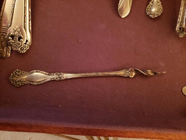 Part of silverware set. It has a corkscrew tip, but it is not sturdy enough to be used as s corkscrew. Thoughts for its purpose?A: It’s a butter pick.