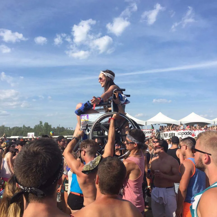 “Girl in a wheelchair being lifted to see the front stage at the Escapade Music Festival, Ottawa”