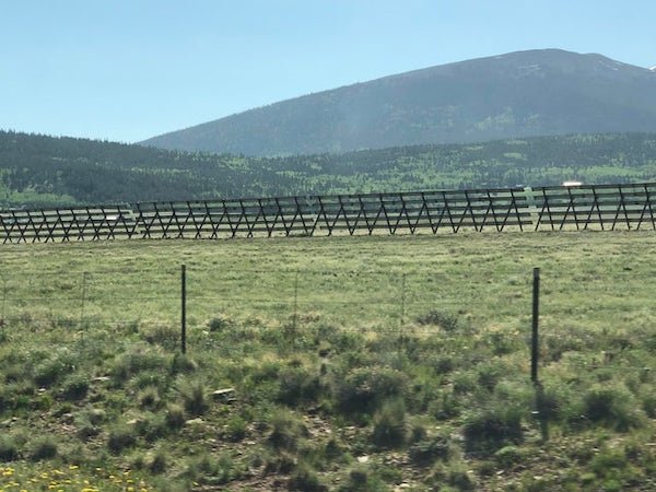 Driving past farmland/ranches in the middle of Colorado. These are always parallel to the highway and at least somewhat close.

A: snow fence, they keep snow from drifting onto the highway