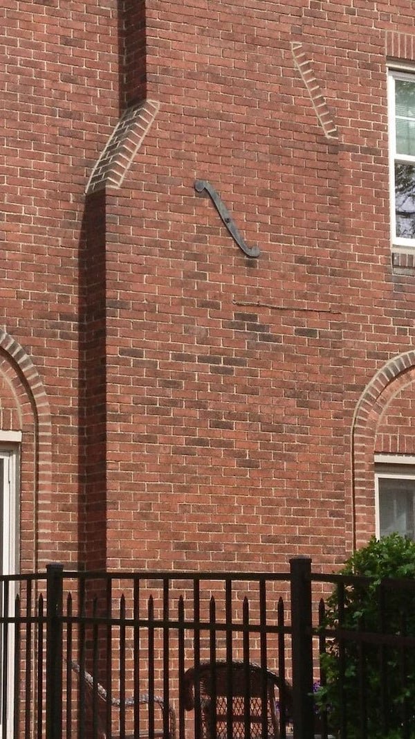 What is this S-shaped metal ornament on this house?

A: Anchor plate or wall washer. It’s meant to keep masonry in place. And made esthetic because they are visible. There a bolt going on the other side, in the center. And hold the bricks in place.