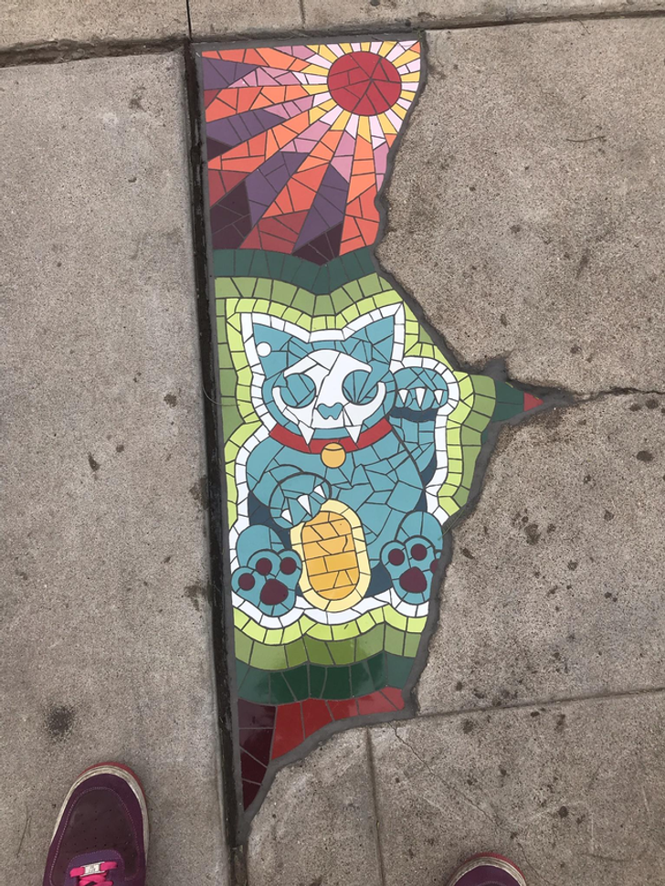 “This crack in the pavement is filled with a stained-glass cat portrait.”