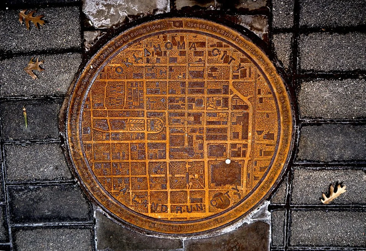 “An old manhole cover in Oklahoma City bears a map of the city.”