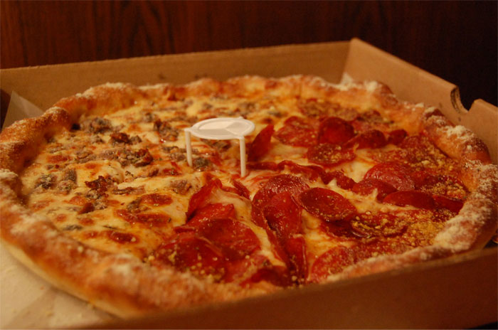 The tiny plastic thing placed in the middle of a pizza box is called a pizza saver.