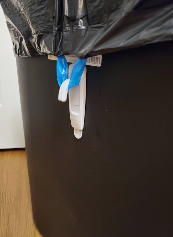 Not sure if lifehack but my wife was impressed with the idea. 3M hanger upside down to keep trashbag in place.