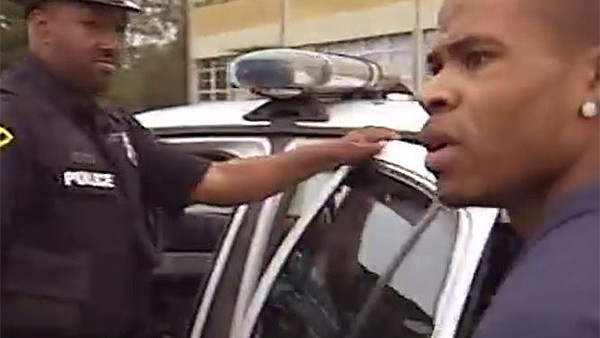 This still from video news coverage shows one of the last ever images of police officer Steven Green, shortly before he was stabbed to death by the suspect on the right.
While cuffed, the suspect was able to somehow stab Green in the sally port of the jail he was to be held in. Following the stabbing, the suspect was able to escape, but was tracked down by police a short while later. A gunfight ensued as the suspect hid beneath a home, and he was killed in an “exchange of gunfire”.