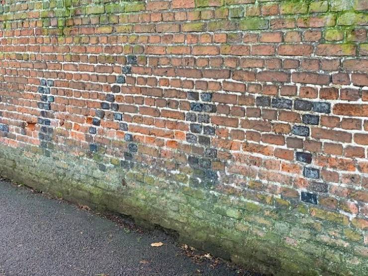 “The builder of this wall wrote the date that he finished it using black bricks.”