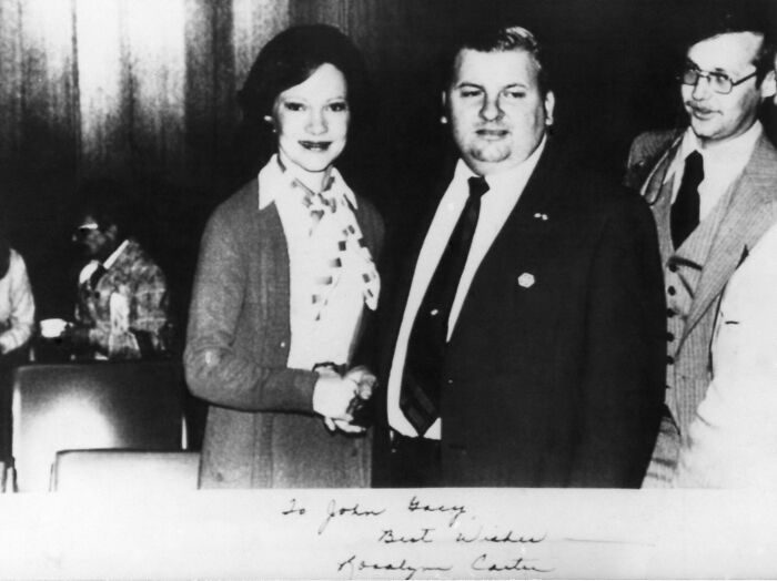 This is a picture of First Lady Rosalynn Carter in 1978 shaking hands with serial killer John Wayne Gacy, who was active in politics at the time. By that time, he had already killed over 20 young men. He's wearing an "S" on his lapel, which was given to him by the Secret Service to indicate that he'd been given security clearance. The picture was even signed, "To John Gacy, best wishes, Rosalynn Carter."
