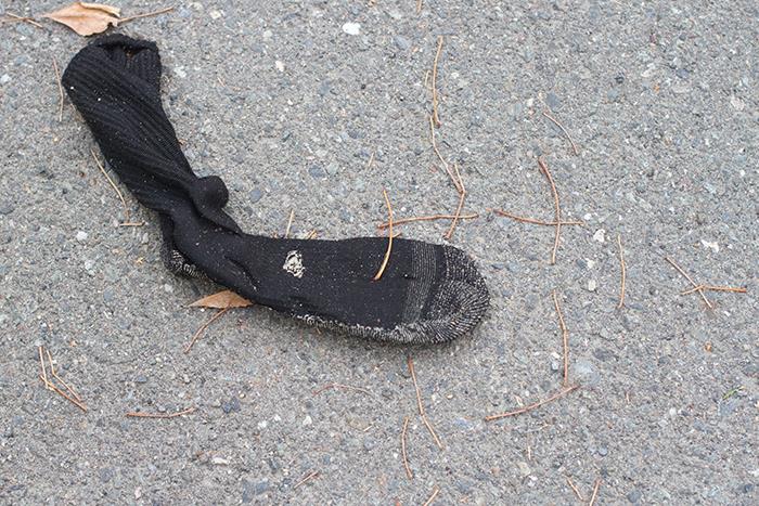 dirty sock on pavement