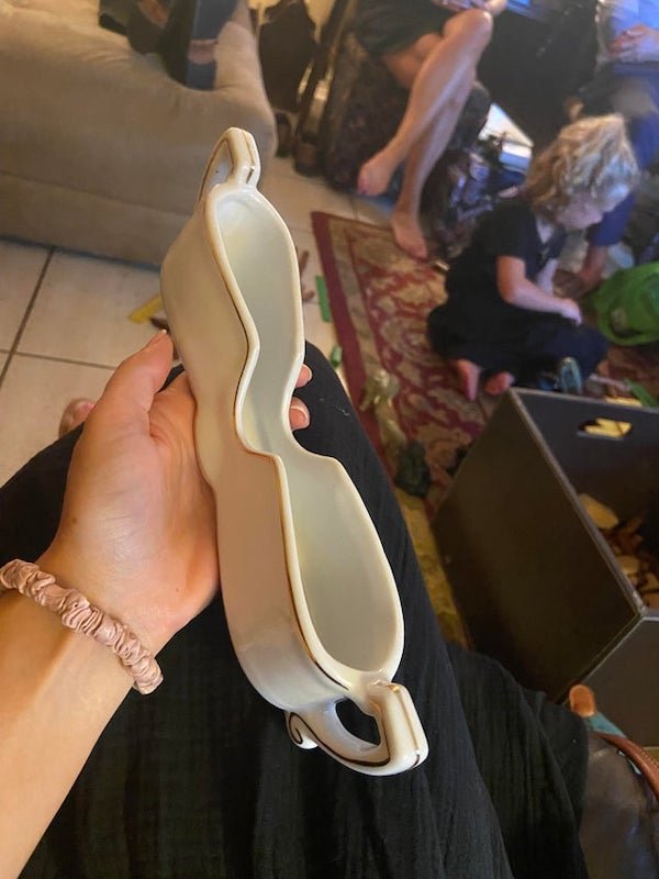 What is this piece of china? Found 3 in a set.

A: Perhaps it is for silverware. The slots on the side for your fingers to easily grab them out. A foot seems kinda long though so i’m unsure. Very unlikely thought is perhaps a rice paper holder?
