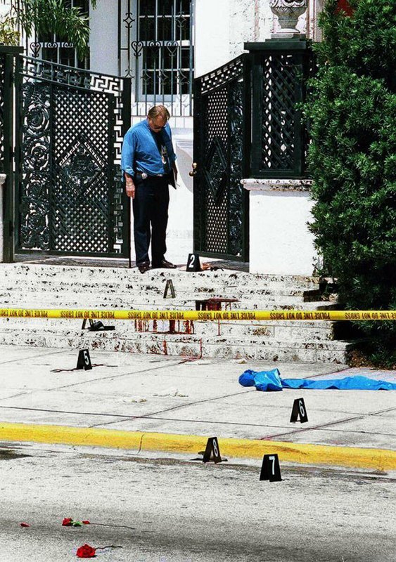 A police officer looks over the bloodstained entrance where fashion designer Gianni Versace was shot and killed by Andrew Cunanan, July 15, 1997