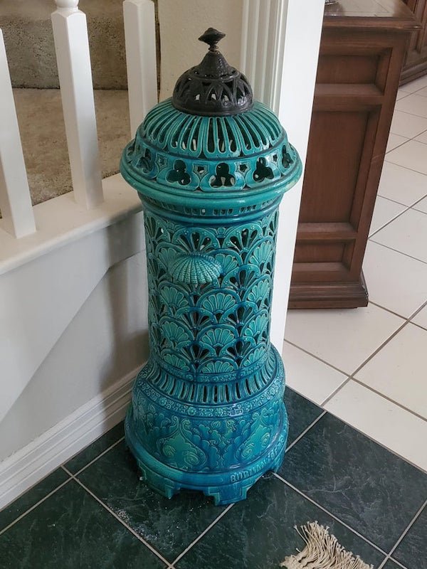 This large, ceramic, turquoise fire hydrant looking thing has been in the family for decades. Resembles some sort of large lantern, but still unsure.

A: I believe it’s a small heater, probably gas. Mostly decorative to protect people from the flame.