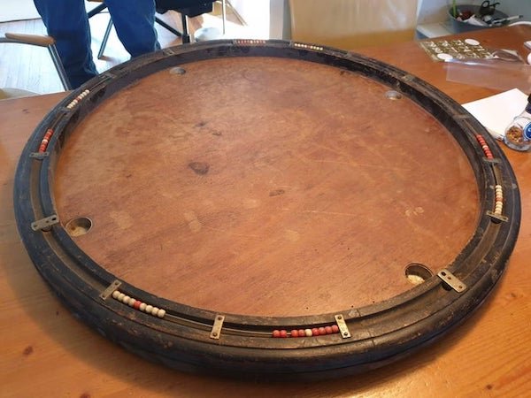 What is this large wooden board with movable red and white beads on the rim? Looks like game (table) with beads to keep score, but what type of game?

A: It’s called a Billard Nicholas. It appears to be a French game of some sort.