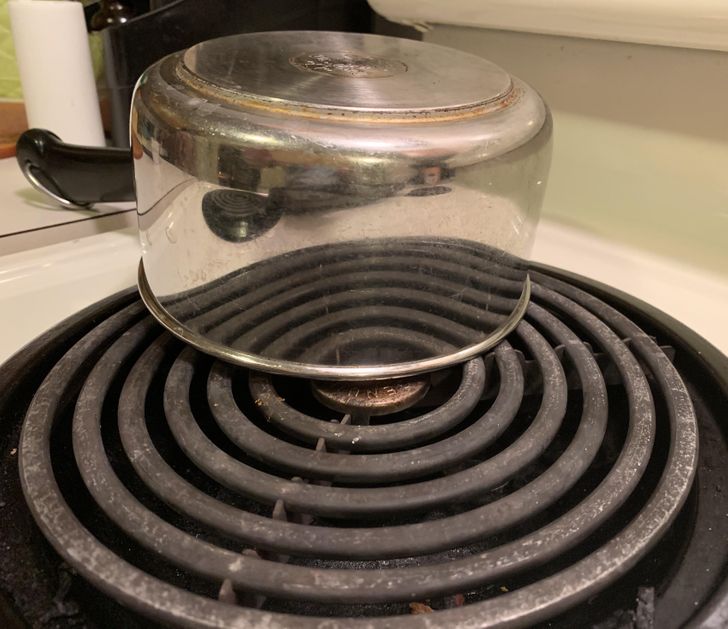 “A metal saucepan’s reflection of a burner makes it appear transparent.”