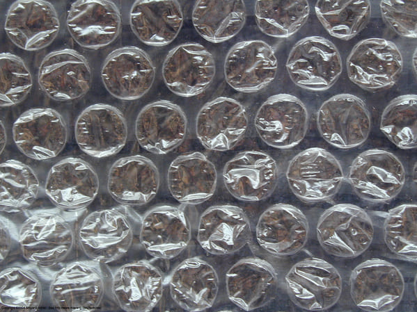 “Bubble wrap was invented in 1957 by engineers Alfred Fielding and Marc Chavannes in Hawthorne, New Jersey. Fielding and Chavannes sealed two shower curtains together, creating a smattering of air bubbles, which they originally tried to sell as wallpaper. When the product turned out to be unsuccessful as wallpaper, the team marketed it as greenhouse insulation. Although Bubble Wrap was branded by Sealed Air Corporation (founded by Fielding and Chavannes) in 1960, it was not until a year later that its use in protective usage was discovered.”