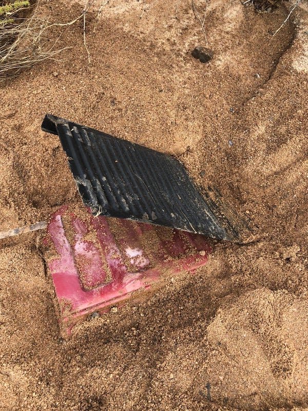 2′ wide, shallow, flat bottom box found buried in a wash in AZ. Black weather guard was bolted down on the top at some point.

A: Looks to me like the tailgate off a pickup truck with a bed liner attached to it.