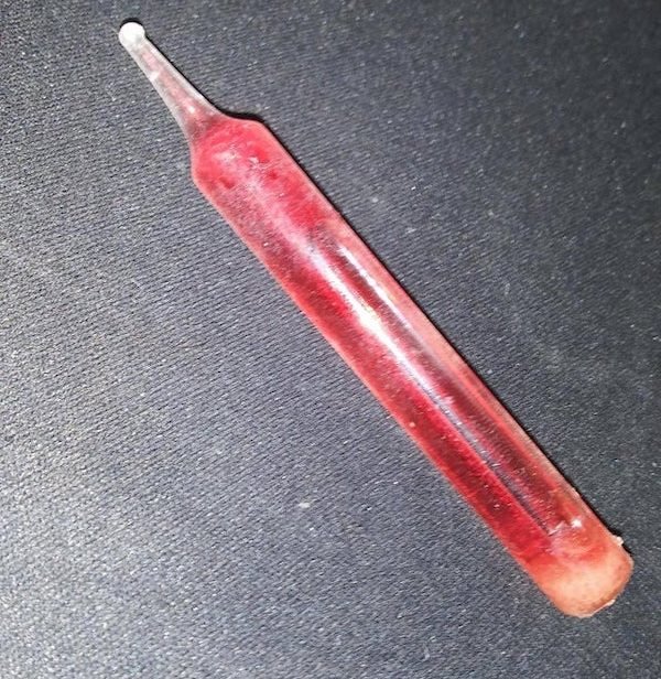 Sealed glass vial with red liquid inside

A: That’s an old style of Christmas light. It’s missing the actual light part, but it would heat up and little bubbles would rise through the tube, looking pretty.