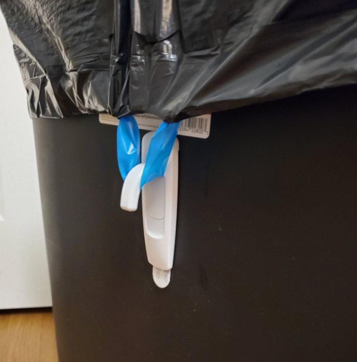 A trash bag almost never stays properly put inside the bin. It often crumples and falls down, while its edges can become dirty from coming into contact with wet garbage. To prevent this from happening, just glue hooks to the outer walls of the waste basket, to which you can easily attach the bag handles.