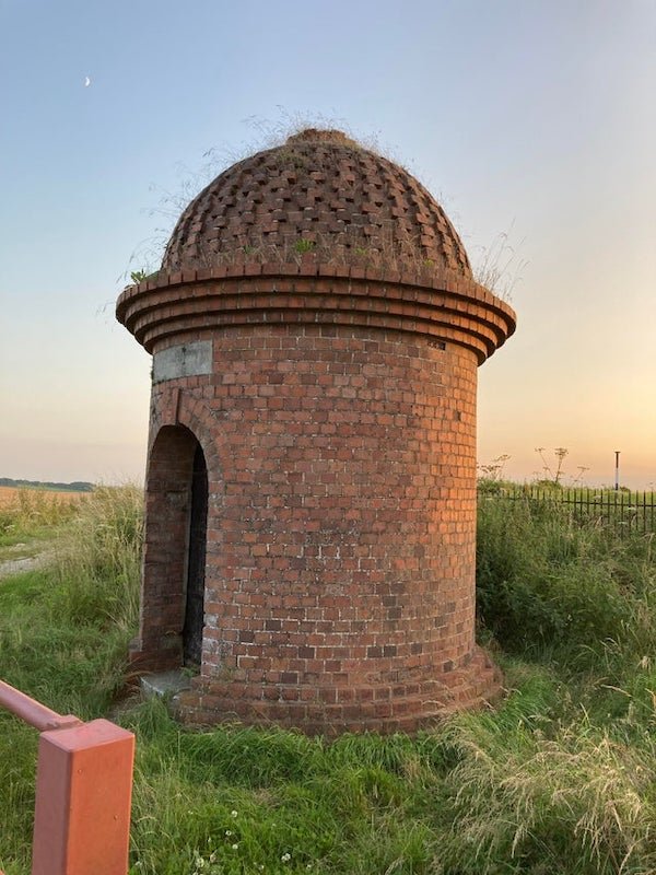 What is this large brick structure? Found at the edge of a field in South England.

A: It’s an old pumphouse.