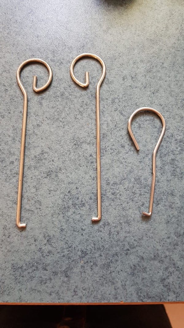 Found this in the kitchen. They appear to be some kind of hooks, no idea what for though.

A: We have one for our bread makers. To pull out the handle when its hot.