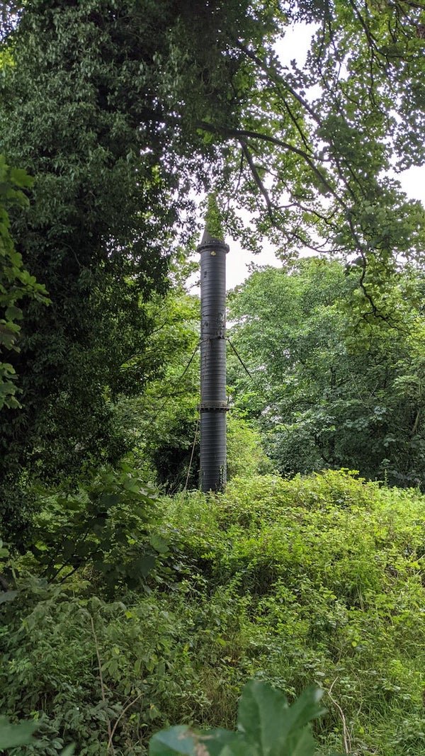 Found in central Edinburgh. About a half metre in diameter, 3-4 metres in height, dark metal. Located just off a main road next to a burn. What is this thing?

A: Stink pipe for venting sewer gas