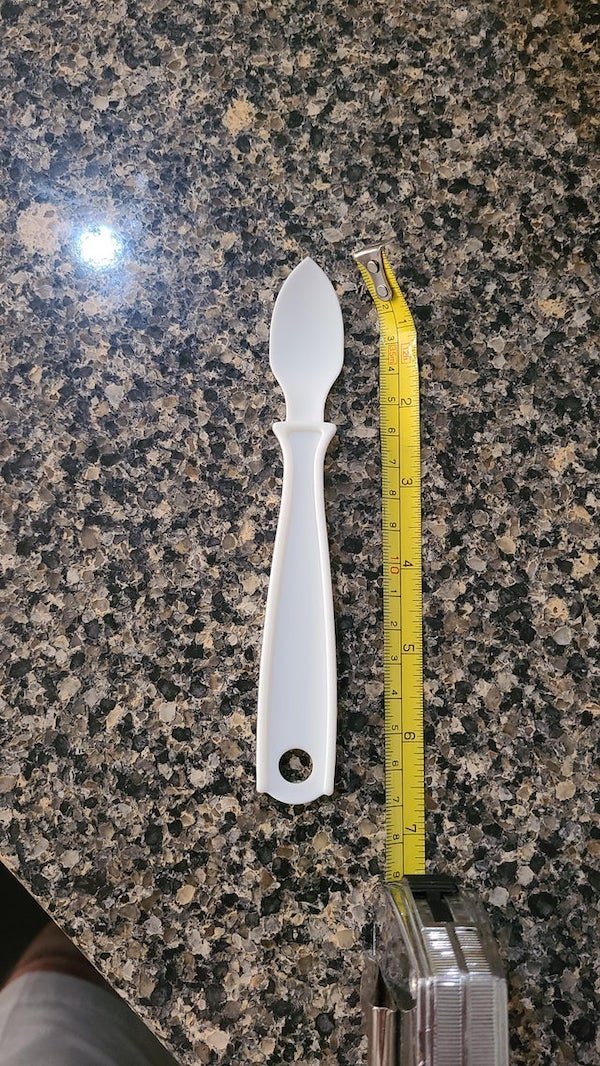 6.5″ white bendable plastic, shaped similar to a spoon with a point

A: It’s to take cooked eggs out of an egg mold