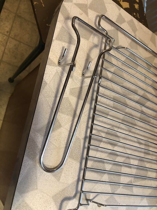 This rack piece came with our new oven. Not mentioned in manual and no obvious way to mount or use it. What is it for? Shown next to one of the oven racks for comparison.

A: It’s the handle for that wire rack next to it. To be used when the rack is hot.