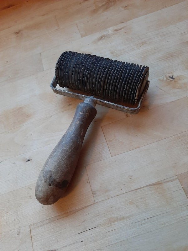 What is this rolling tool? Wooden handle with a spool of metal disc’s. Each disc has the same pattern of notches.

A: It is not for noodles/pasta. It is in german/austrian a Strudelwalze or Stippenroller; could be transalted as gridcutter maybe. It is used for cutting the top of a „Strudel“.