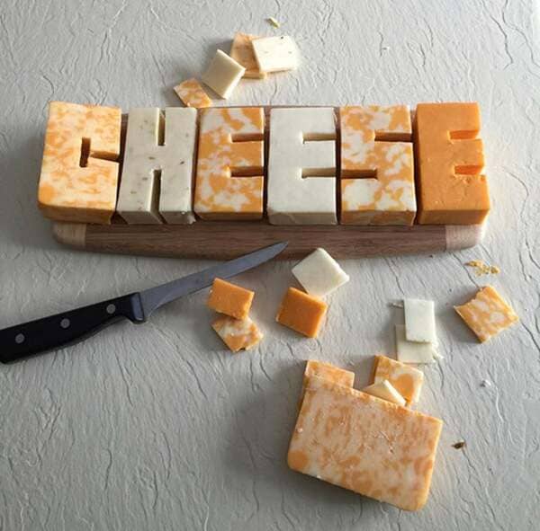 The word CHEESE carved out of cheese.