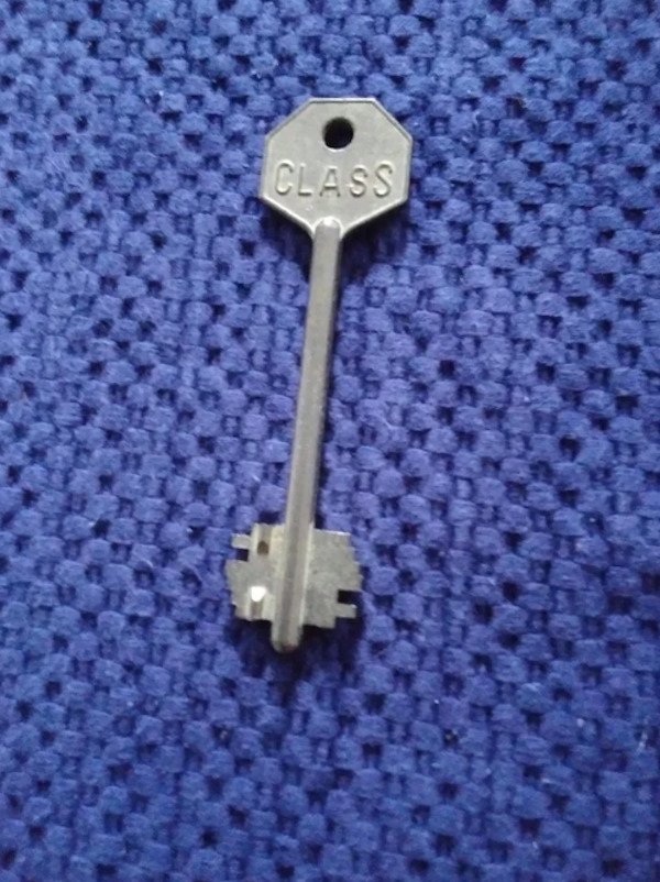 This key is metal, gold color, heavy. It is 3 inches long. It says CLASS on one side. I found it in a storage locker in Fort Wayne Indiana USA. Does this open a vault somewhere?

A: Safety deposit box key. Without a bank location and a box number it’s merely an oddity.