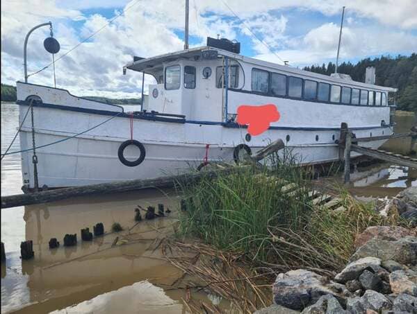 My uncle’s 115yo boat, currently sitting on some rocks and leaking fuel after the anchor snapped.