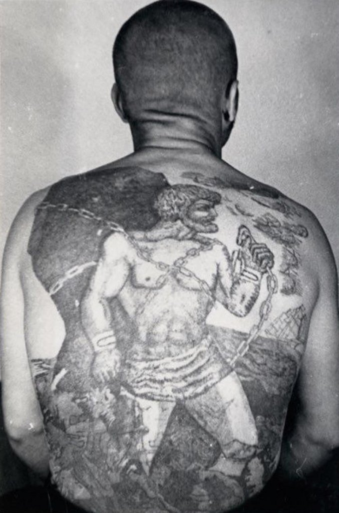 This tattoo is a variation on the myth of Pometheus, who, after tricking Zeus, is chained to a rock in eternal punishment.
The sailing ship with white sails means the bearer does not engage in normal work; he is a traveling thief prone to escape.