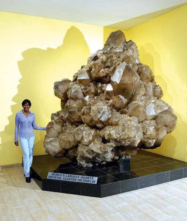 Quartz crystal cluster on display in a museum in Namibia. This is the world’s largest quartz cluster, it was discovered in 1985 at the bottom of a 45-meter deep cave in the Otjua mine near Karibib in Namibia. It weighs 14,100 kg and took three years to excavate and remove.